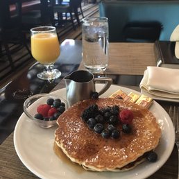 Short stack (3) of pancakes with seasonal fruit and maple syrup