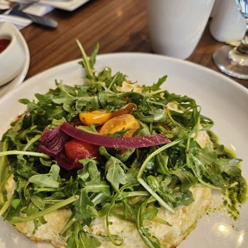 Borealis - Salmon fritata - A fresh salad featuring arugula, cherry tomatoes, and pickled vegetables on a white plate, with a coffee mug and other dishes in the background. - Diners Near Me - Aurora, Colorado