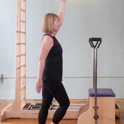 Pilates Works - Standing leg pump exercise on the Balanced Body Combo Split Pedal Chair with CoreAlign in the background. Photo by Carolyn Bauman Cruz.