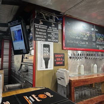 The 377 Brewery - The image shows the inside of a brewery with signs on the wall, a chalkboard menu listing beers, and beer taps. There are beer mats and glasses on the counter. - Brewpubs Near Me - Albuquerque, New Mexico