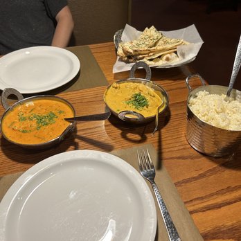 Bombay House - a wooden table with plates of food and utensils - Indian Near Me - Provo, Utah Bombay House - a wooden table with plates of food and utensils - Indian Near Me - Provo, Utah