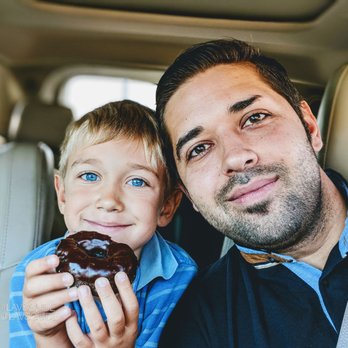 Dunkin' -  a man and a young boy eating a donut - Donuts Near Me - Hillside, Illinois