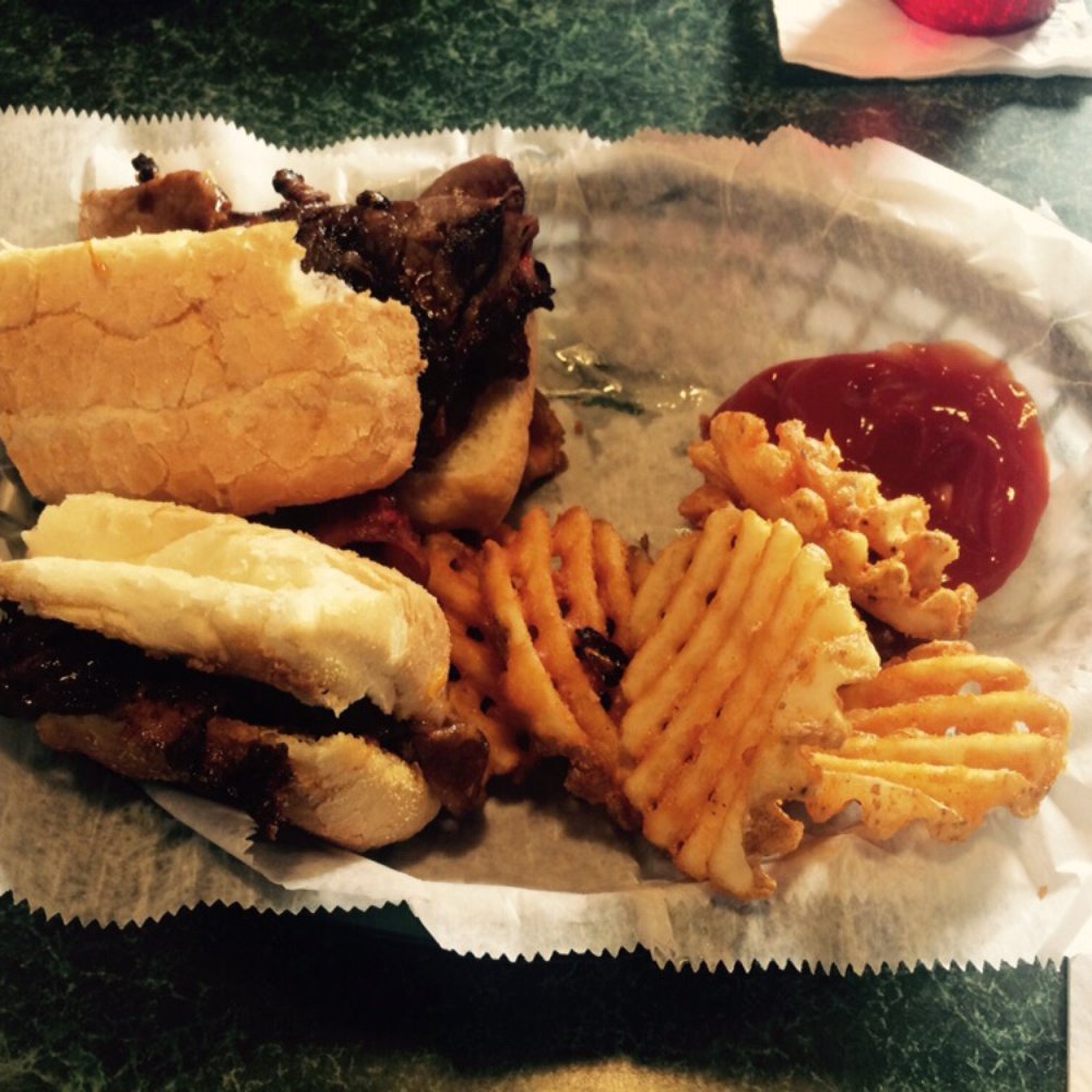 a basket of food including a sandwich, fries, and ketchup