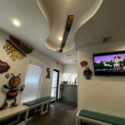 Dr Bee Pediatric Dentistry - Waiting area with children's programming on.