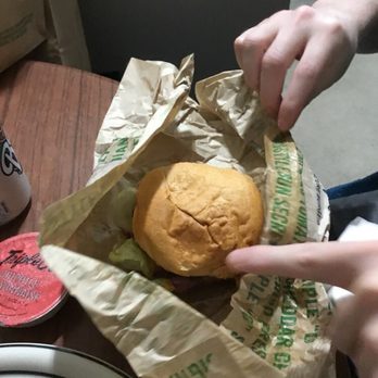Triple O's - a person holding a sandwich in a paper bag - Burgers Near Me - Delta, British Columbia