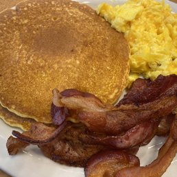 Pancakes, bacon and eggs with cheddar cheese and a cup of coffee Pancakes, bacon and eggs with cheddar cheese and a cup of coffee