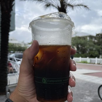 Amavida Coffee Roasters - a hand holding a cup of coffee - Coffee & Tea Near Me - Seaside, Florida