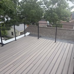 TJ & Sons Roofing & Remodeling - Exterior composite flooring; steel post and wire fencing with a replaced torched roof below.