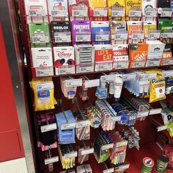 Target - Gift cards - A Target store shelf features a variety of gift cards for different brands and services, along with snacks like chips and candy, and small personal care items such as batteries and lip balm. The display is organized with multiple rows and sections, with price tags visible for each item. - Department Stores Near Me - Arlington Heights, Illinois