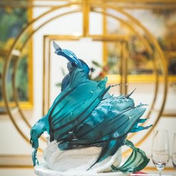 a blue glass sculpture on a table a blue glass sculpture on a table