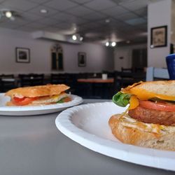 Café 412 - Two halves left of breakfast Sammie. Vegan sausage to the right,  omni in the back. Peek of the cool coffee  mug.