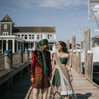 Sari Palace - A man and woman in traditional Indian clothing walk along a marina dock with boats and a building in the background. - Traditional Clothing Near Me - Berkeley, California