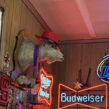 The Roast Grill Hot Weiners - The goat is not displayed like a taxidermy trophy in a hunting lodge. Instead, it is integrated into the layered visual clutter. - Hot Dogs Near Me - Raleigh, North Carolina The Roast Grill Hot Weiners - The goat is not displayed like a taxidermy trophy in a hunting lodge. Instead, it is integrated into the layered visual clutter. - Hot Dogs Near Me - Raleigh, North Carolina