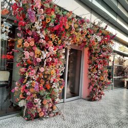 L'Avenida - De inkom van de zaak die de met prachtige kleurrijke bloemen is aangekleed die ook binnen gebruikt zijn in de inkleding van de zaak.