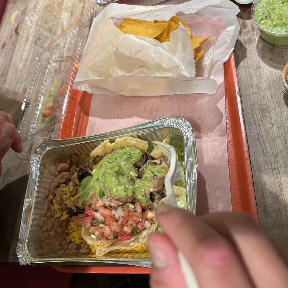 El Rancho Burritos - a person eating a burrito - Mexican Near Me - New York, New York