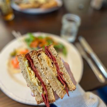 Cateye Cafe - a hand holding a half eaten sandwich - New American Near Me - Bozeman, Montana Cateye Cafe - a hand holding a half eaten sandwich - New American Near Me - Bozeman, Montana