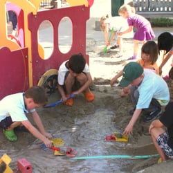 Village Preschool of Saratoga - Fun in the mud. Children playing in the preschool playground.