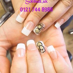 Glitter Nails & Beauty - French tips with black and gold design pattern.