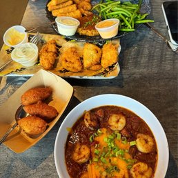 From bottom going up: Cajun Shrimp and Grits (Petite), Hush Puppies, Fried Green Tomatoes, Destin Platter