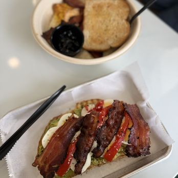 Noontide Coffee Kitchen - Anything + Everything Avocado toast with peppercorn bacon and in the back, Scram-Bowl with grits, bacon, toast! - Juice Bars & Smoothies Near Me - Morehead City, North Carolina Noontide Coffee Kitchen - Anything + Everything Avocado toast with peppercorn bacon and in the back, Scram-Bowl with grits, bacon, toast! - Juice Bars & Smoothies Near Me - Morehead City, North Carolina