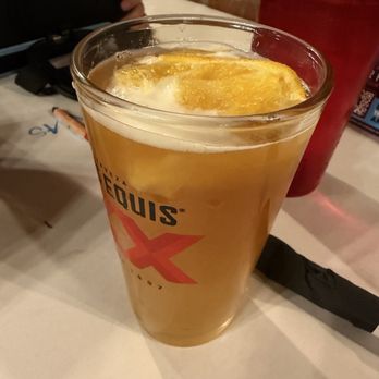 High Point Grill - Blue moons on tap - A pint glass filled with beer and a lemon slice on top, on a table at a restaurant or bar. - Sandwiches Near Me - Albuquerque, New Mexico