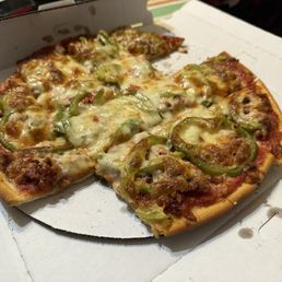 Medium pizza with Italian sausage, peppers, and bacon - A pizza topped with green peppers, melted cheese, and meat, served in a white pizza box.