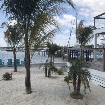 Admirals Beachside Bar - Photo of side deck seating area on right and some of beach area on left. - American Near Me - Rock Hall, Maryland