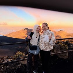 Elite Taxi Tours - Two girls pose in front of sunrise at Halakalea National Park.