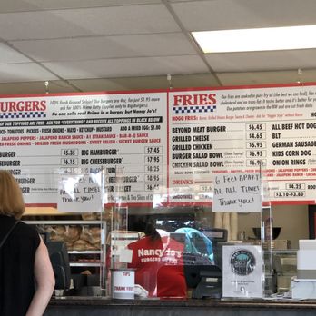 Nancy Jo's - a woman standing in front of a menu - Burgers Near Me - Keizer, Oregon