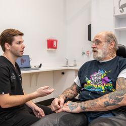 Care Dental Implant and Cosmetic Center - Dr. Drew Phillips chair side with a patient
