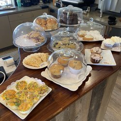 Holy Grounds Cafe - Egg bites, chocolate cake, savory scone, raspberry white chocolate scone, blueberry scone, cinnamon roll, carrot cake, espresso machine.