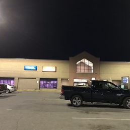 a man walking in a parking lot at night