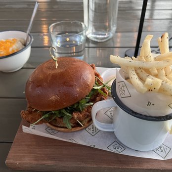 Camp Outpost - Fried chicken sandwich with french fries and a side of cheesy creamy grits - New American Near Me - San Antonio, Texas