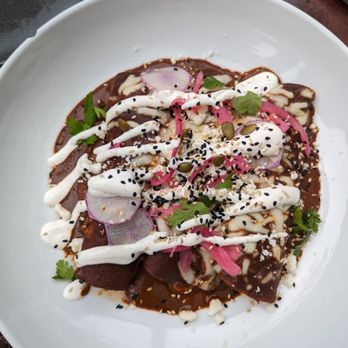 Benchmark - CHICKEN MOLE ENCHILADAS: corn tortillas, confit chicken leg, monterey jack cheese, radish, pickled red onion, queso fresco, sesame seeds $20 - New American Near Me - Santa Ana, California