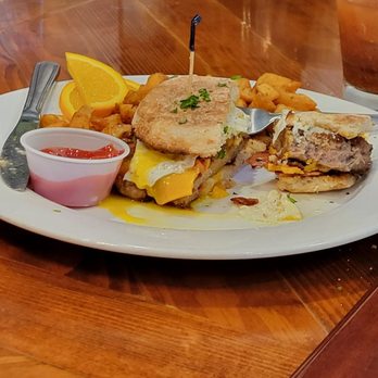 Rustic Table - Snuck a picture of my neighbors sausage breakfast sandwich. As big as a hamburger! - Southern Near Me - Pawleys Island, South Carolina