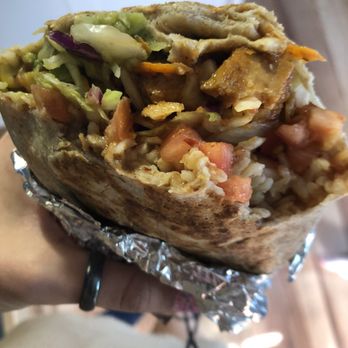 Quesada Burritos & Tacos - a hand holding a burrito - Mexican Near Me - Ajax, Ontario