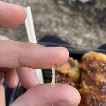 Red 8 - a hand holding a piece of food - Sushi Bars Near Me - Lehi, Utah