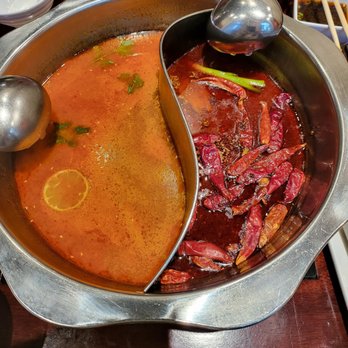 Q Restaurant - Broths - Hot and sour Tomyum on left and spicy beef tallow on right. - Chinese Near Me - Boston, Massachusetts Q Restaurant - Broths - Hot and sour Tomyum on left and spicy beef tallow on right. - Chinese Near Me - Boston, Massachusetts