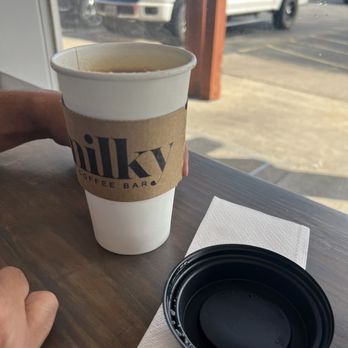 Milky Coffee Bar - a person sitting at a table with a cup of coffee - Coffee & Tea Near Me - Corpus Christi, Texas