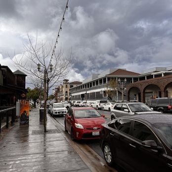 Old Town Temecula - A street view in a historic district shows parked cars along a wet sidewalk with a cloudy sky overhead. - Local Flavor Near Me - Temecula, California
