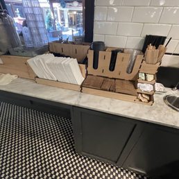 Utensils, napkins, and coffee stuff can be found here