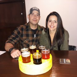CheezHead Brewing - Customers enjoying THE BIG CHEEZ flight of beers served in a cheez wheel.