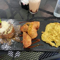 Breakfast board with cinnamon bun French toast, breakfast egg rolls and scrambled eggs