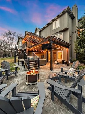 Outdoor Retreat in Olathe, Kansas - The existing deck was replaced with a steel-framed composite deck, two-tier cedar pergolas, and a stamped concrete patio with a firepit. The deck is designed to facilitate easy entry to a ground-level spa. This outdoor getaway can function 24 hours a day, 7 days a week, 365 days a year. Outdoor Retreat in Olathe, Kansas - The existing deck was replaced with a steel-framed composite deck, two-tier cedar pergolas, and a stamped concrete patio with a firepit. The deck is designed to facilitate easy entry to a ground-level spa. This outdoor getaway can function 24 hours a day, 7 days a week, 365 days a year.