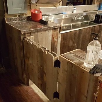 The Alibi - a kitchen with wooden cabinets and a sink - Bars Near Me - Milliken, Colorado