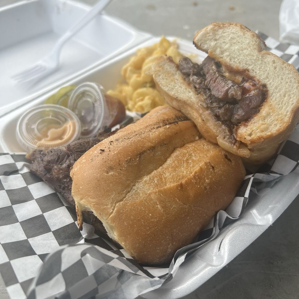 Rollin Flame BBQ - A ribeye steak sandwich w grilled onions and a side of mac n cheese. Made to perfection - Food Trucks Near Me Rollin Flame BBQ - A ribeye steak sandwich w grilled onions and a side of mac n cheese. Made to perfection - Food Trucks Near Me