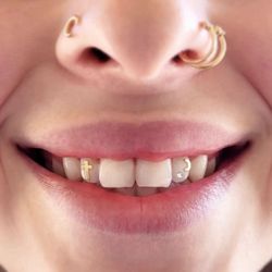 Ivy Noir Piercing & Jewelry - Cubic zirconia and 14k gold tooth gems.

Applied using dental adhesive by tooth gem technician. No drilling required.