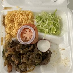 a styrofoam takeout box with meat, rice, and vegetables