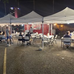 Food truck set up at night. Nice covered seating with lights. The waiters are very attentive and polite. The food is outstanding.