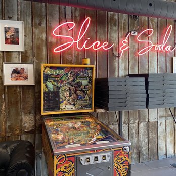 Slice + Soda - a pinball machine with a neon sign - Pizza Near Me - Montreal, Quebec